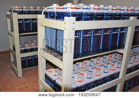 Rack with battery DC accumulators for powerful supply industrial equipment of energy station. Battery direct current with plus and minus terminal