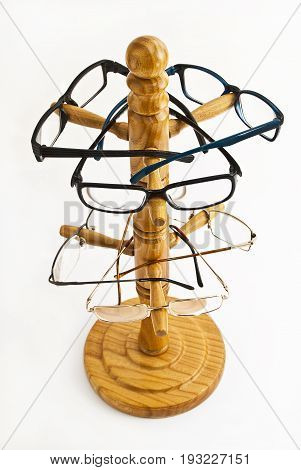 Wooden rack with dioptric glasses on a white background