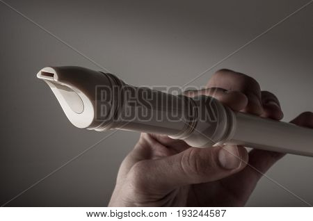 Classic musical instrument flute in hand on black background.