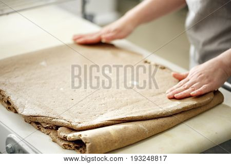 the Baker rolls rye puff pastry on special equipment. blank dough for baking in the bakery