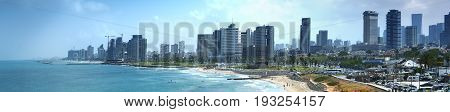 Tel Aviv skyline by day with beach sea and waves
