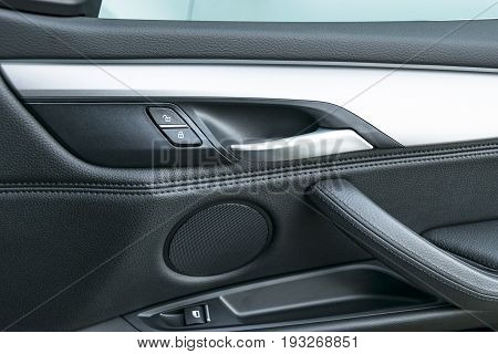 Car door handle inside the luxury modern car with black leather and switch button control modern car interior details
