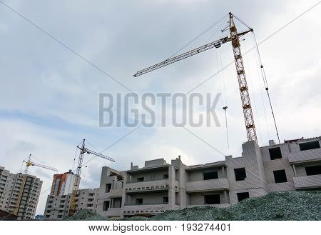 two high tower crane and building under construction against the dark sky.