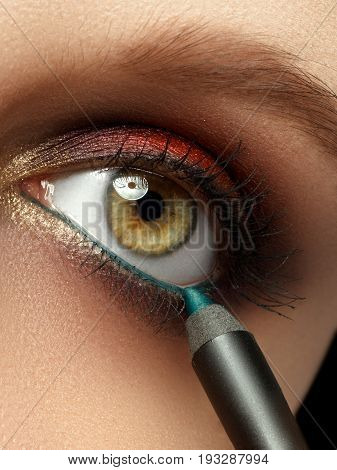 Make-up With Black Eyeliner Close-up. Make-up Artist Applying Eyeliner Pencil On A Model With Green