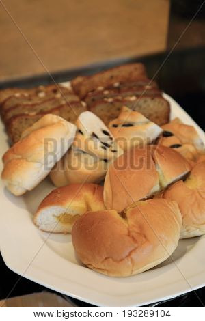 Many kind of breads on white dish for breakfast.