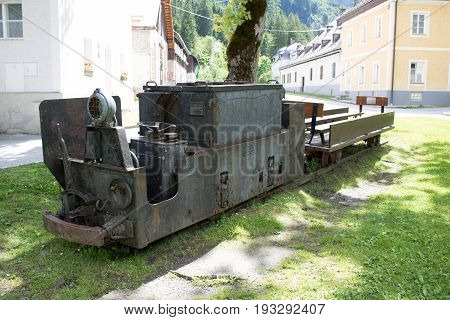 Bad Gastein Austria - JUNE 09 2017: Old mining truck in front of the Health resort Heilstollen a former mining tunnel. Near Bad Gastein Austria Europe. Hammer and pick as symbols of mining.