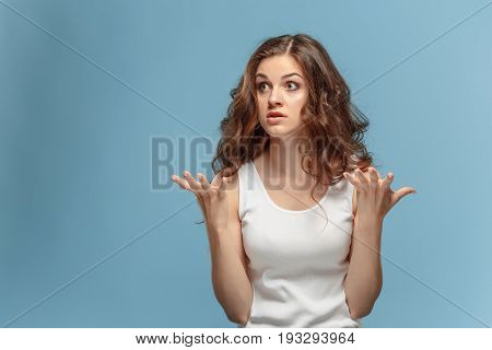 Portrait of an angry woman looking away on a blue background