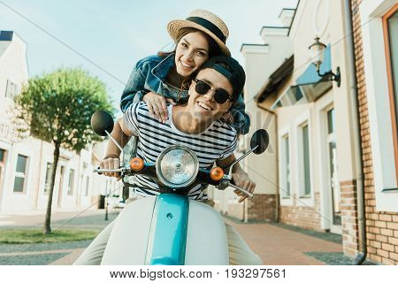 Happy Young Woman In Straw Hat And Handsome Man In Sunglases Riding Scooter Together