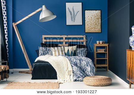 Stylish bedroom interior with dark blue wall