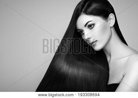 Beautiful woman with long smooth hair. Girl with perfect makeup. Model brunette with perfect healthy dark hair. Black and White photo