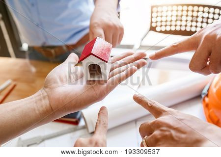 Teamwork Of Architectural Engineer Consulting On The Creation Of A Model Home, Hands Pointing To Min