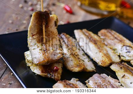 closeup of a plate with some spanish sardine fillets served as tapas, on a rustic wooden table