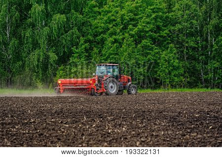 Farmer Seeding Crops On Tractor At Field. Russia