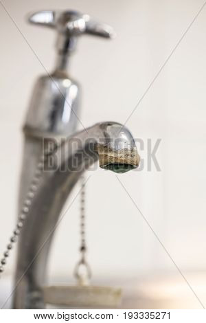 Limescale deposit on tap. Selective focus on limescale on spout of faucet. Hard water plumbing problem.
