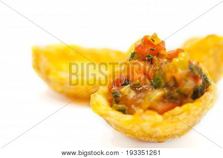 Plantain cup, made of crushed fried green plantains, filled with hogao on white background