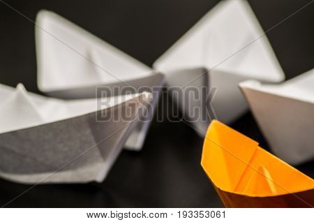 one origami ship meets other ships on black