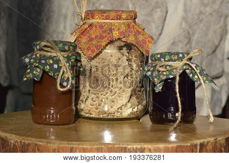 Jars of jam and Dried mushrooms - Macrolepiota procera on wooden board