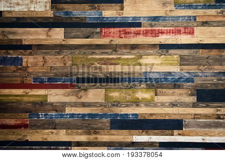 Wall made of multi-colored wooden boards. Abstract grunge wood texture background.