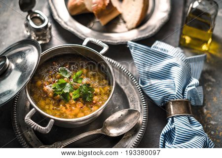 Greek chickpea soup in the pot on the stone background horizontal