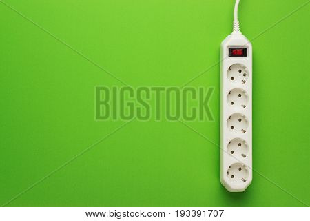 European 5-way power strip. power strip with 5 sockets. European power strip earthed on green background. 5-way power strip with copy space