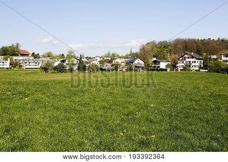 Bern Switzerland - April 14 2017: Spring green meadow completed with a number of residential homes is an example of the tranquility of the landscape that you can see from the Murifeld of Bern