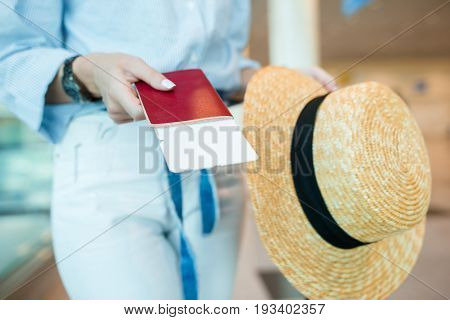 Closeup of woman holding passports and boarding pass at airport