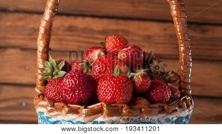 Strawberries in basket on wooden background, closeup