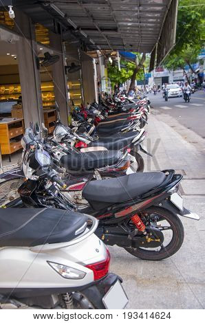 Street in a Vietnamese citya lot of parked bikes.