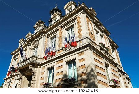The city hall of Maisons Laffitte town decorated with national French flags, parisian region, France.