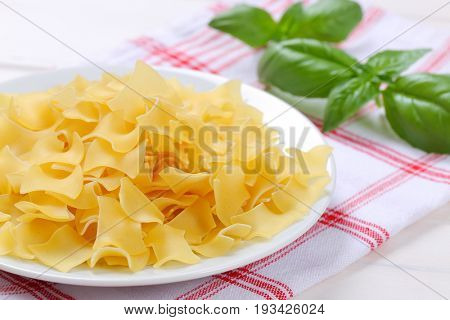 plate of quadretti - square shaped pasta on checkered dishtowel - close up