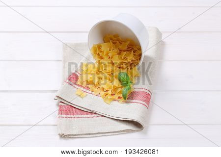 bowl of quadretti - square shaped pasta spilt out on place mat