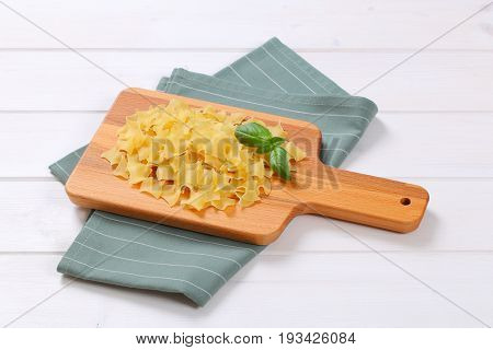 pile of quadretti - square shaped pasta on wooden cutting board