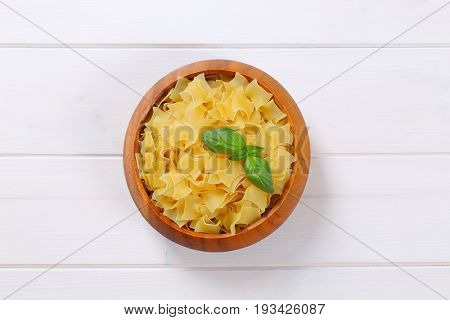 bowl of quadretti - square shaped pasta on white wooden background