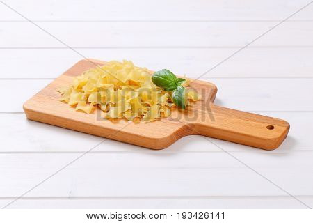 pile of quadretti - square shaped pasta on wooden cutting board