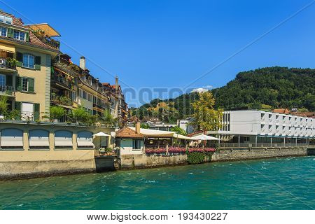 Thun, Switzerland - 21 July, 2015: buildings along the Aare river in the city of Thun in summer. Thun is a city and municipality in the administrative district of Thun in the Swiss canton of Bern, located where the Aare river flows out of Lake Thun.
