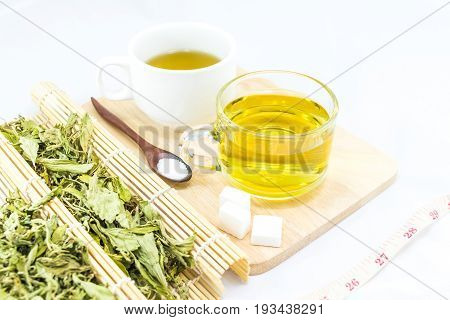 Stevia leaves with a cup stevia infusion on white background