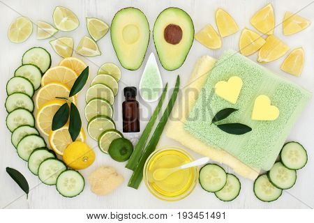 Body and skin care aromatherapy beauty treatment with cucumber, avocado, aloe vera and citrus fruit with essential oil, exfoliating salt and flannels on distressed white wood background. 
