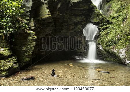 Beautiful Flowing Waterfall With Magical Fairytale Feel In Lush Green Forest Location