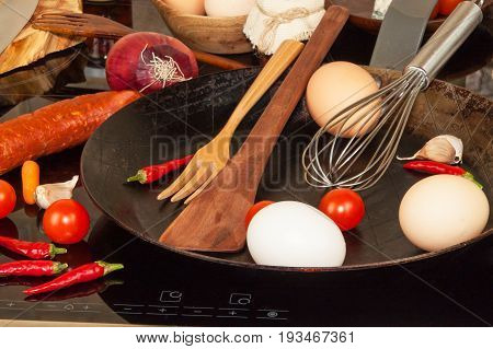 Steel frying pan on the stove. Kitchen utensils. Preparation of egg omelette. Diet food