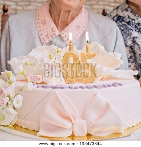 Cake with burning candles 95 years old grandmother