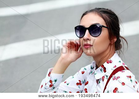 A Beautiful Brunette Smiling Young Woman In Sunglasess And Shirt With Funny Print Cherry And Braces