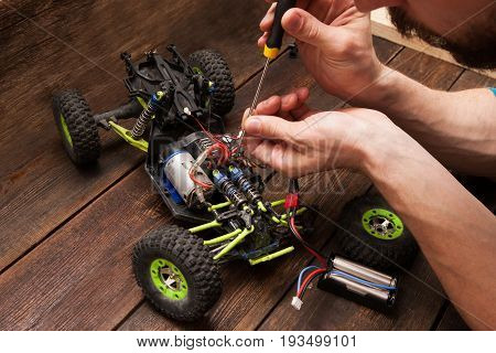 Rc radio control car crawler model toy electronics repair. Green toy suv in repairshop workplace, free space