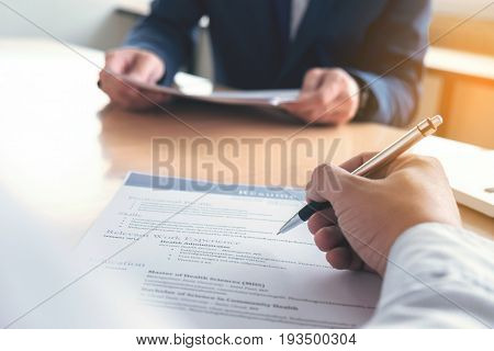 Executive reading a resume during a job interview and businessman Completing Application Form. Hiring concept.