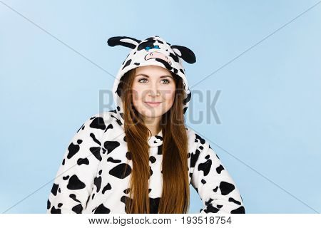 Happy teenage girl in funny nightclothes pajamas cartoon style smiling positive face expression studio shot on blue.