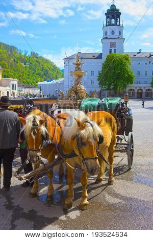 Central place in Salzburg city with carriages and horses, Austria