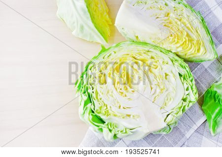 fresh green cut head of cabbage on ceramic gray plate, wooden and natural material background, copy space