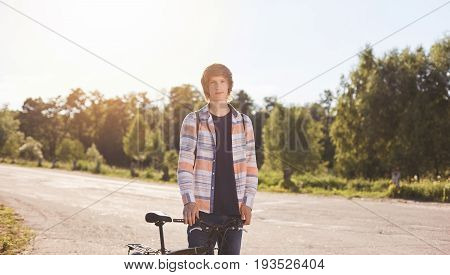 Active Summer Holidays. Portrait Of Young Biker Dessed In Casual Shirt Looking Seriously Into Camera