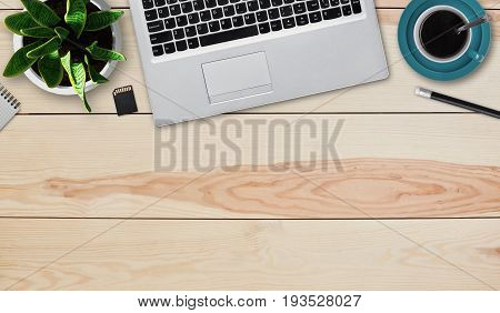 Laptop cup of coffee chip pencil and pot with flower laying on wooden table with copy space for promotional text advertisment or hearder. Image with modern supplies for work and web design