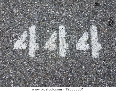 the number 444 painted with a stencil on black asphalt