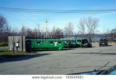 BAY VIEW, MICHIGAN / UNITED STATES - NOVEMBER 26, 2016: People bring their recyclable materials to place in green recycling bins.